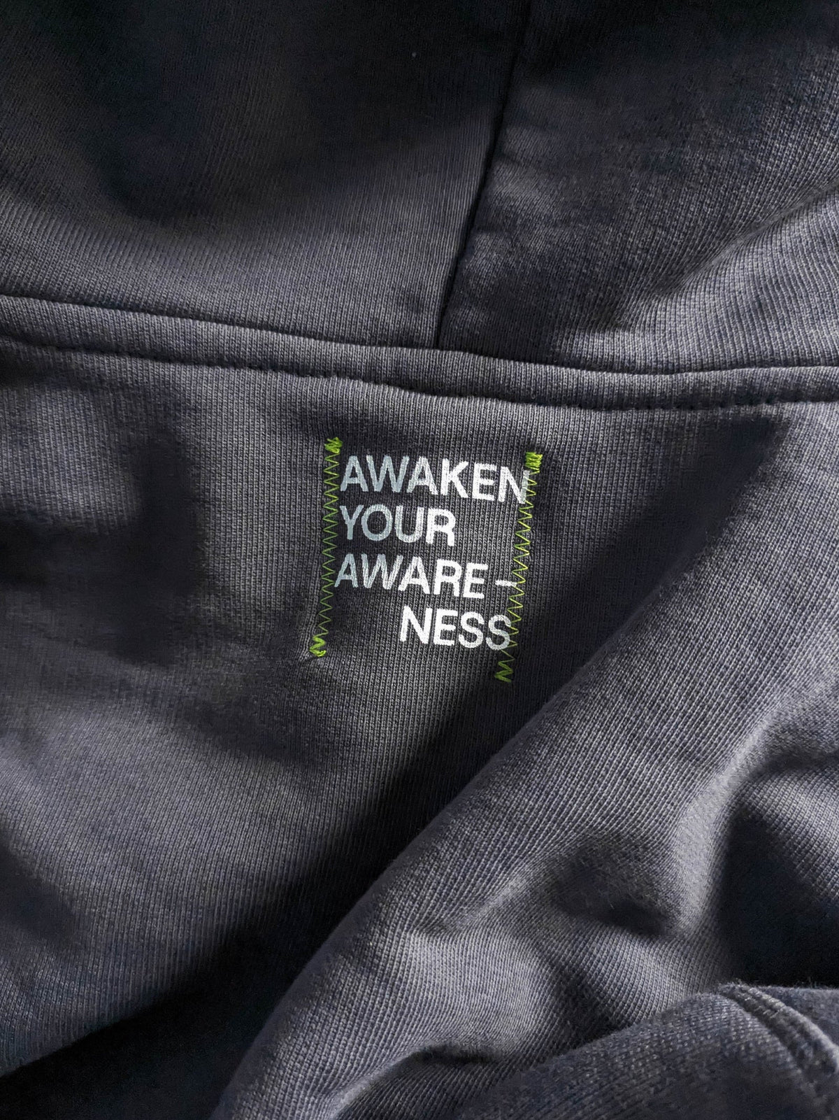 Text label on a gray fabric with a moto.